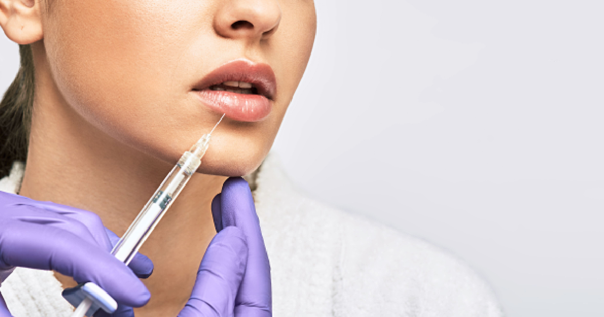 A woman receiving a Juvederm lip filler injection in Rutherford, NJ from a professional wearing purple medical gloves.